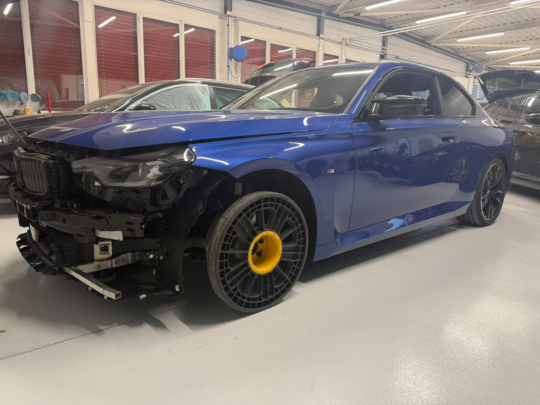 BMW bleue en cours de réparation dans l'atelier
